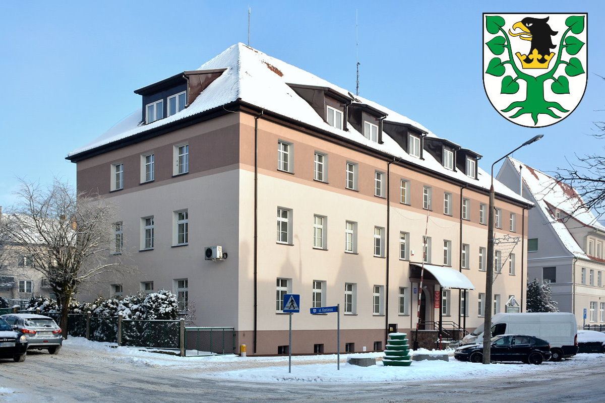 Budynek Starostwa Powiatowego w Olecku. Dwupiętrowy budynek z dachem pokrytym czerwoną dachówką.