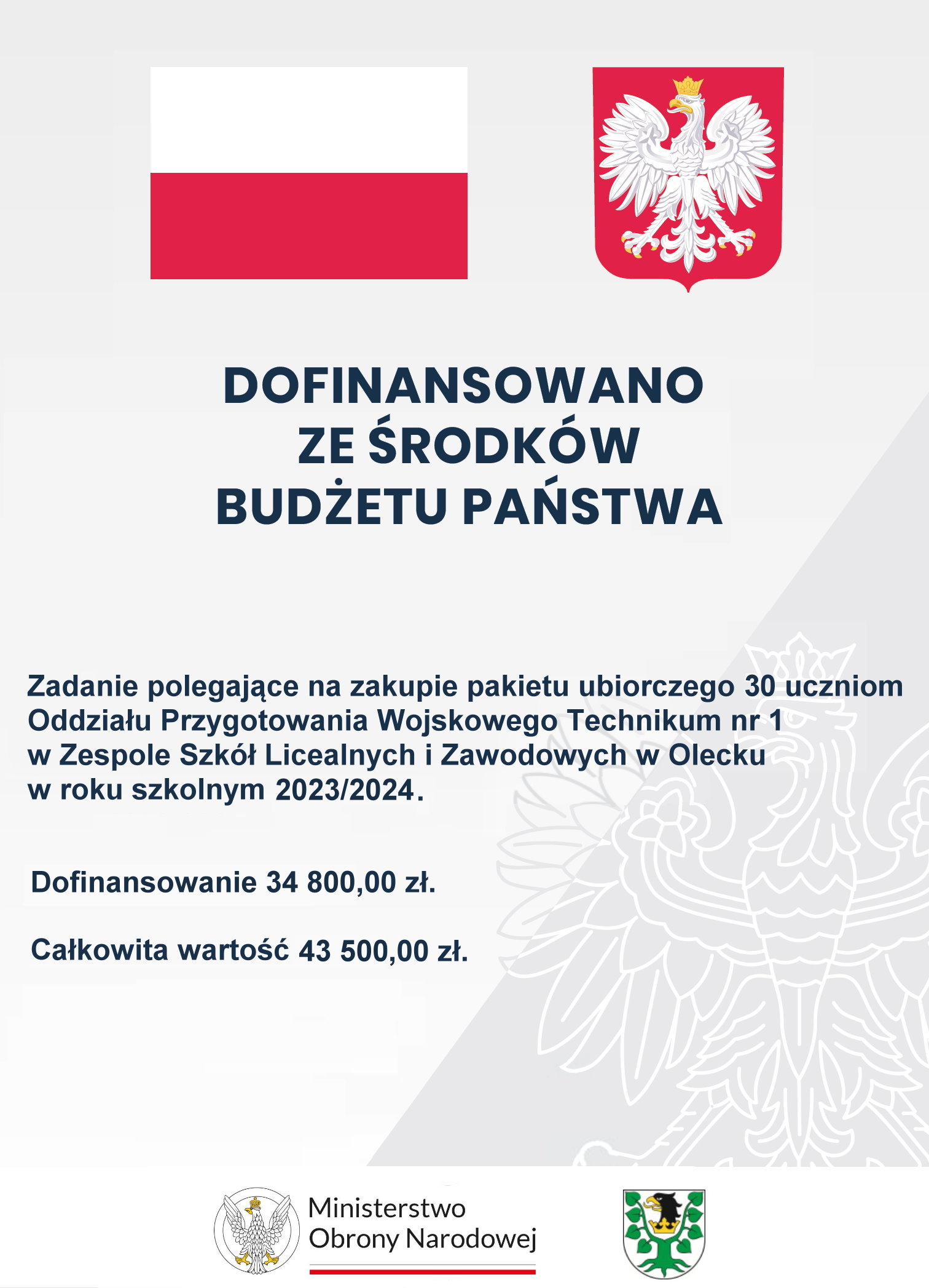 Na górze flaga i godło Polski. Pod nimi napisy. Dofinansowano ze środków budżetu państwa. Zadanie polegające na zakupie pakietu ubiorczego 30 uczniom Oddziału Przygotowania Wojskowego Technikum nr 1 w Zespole Szkół Licealnych i Zawodowych w Olecku w roku szkolnym 2023/2024. Dofinansowanie 34 800 zł. Całkowita wartość 43 500 zł. Na dole 2 logotypy, tj. ministerstwa i urzędu. Jeden składa się z orła po lewej i napisu po prawej: Ministerstwo Obrony Narodowej. Pod napisem barwy Polski. Drugi to herb Powiatu Oleckiego. Przedstawia on głowę orła z dziobem i koroną na szyi pomiędzy 2 konarami lipy, z których każdy ma 4 liście.